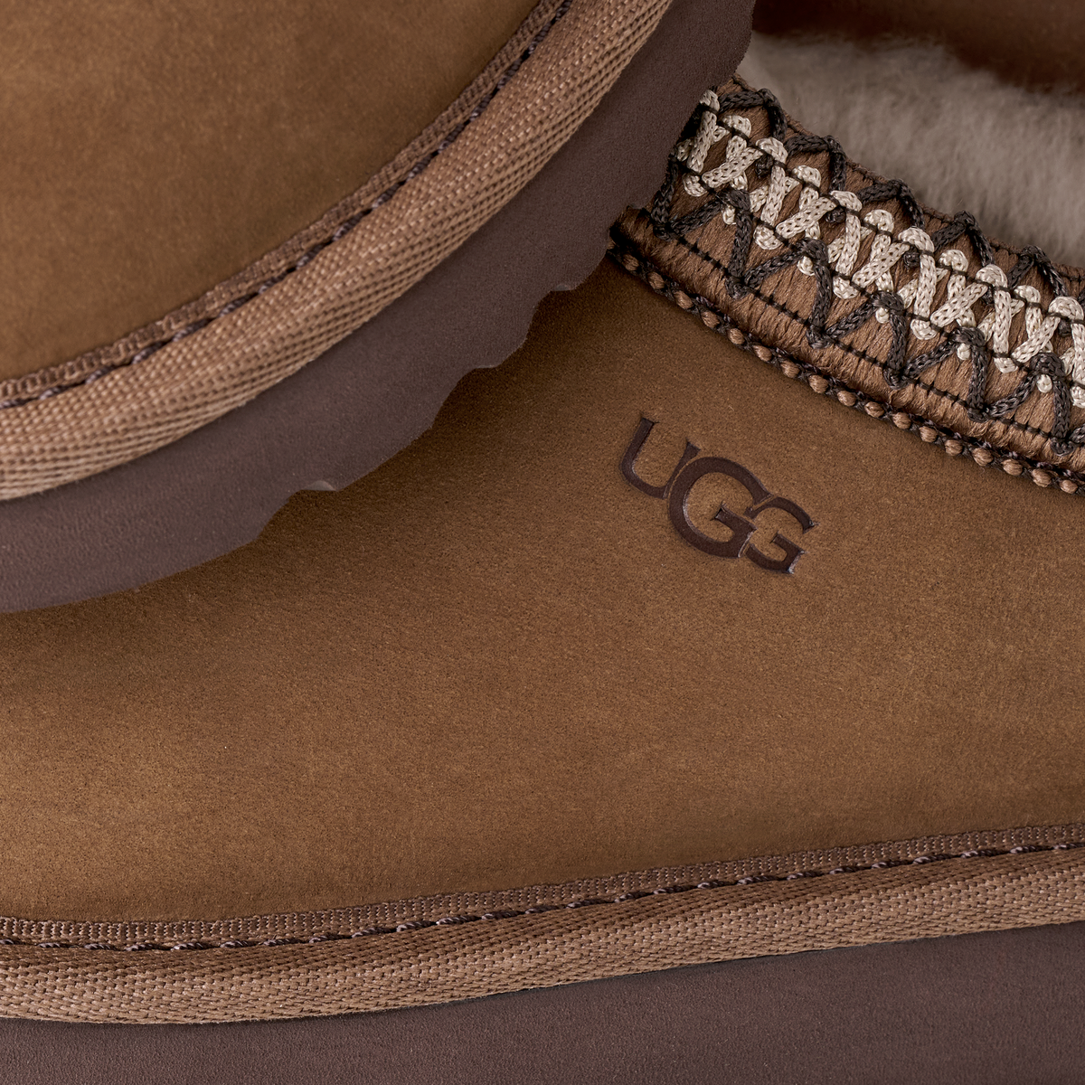 Close-up of a brown UGG slipper with stitching detail.