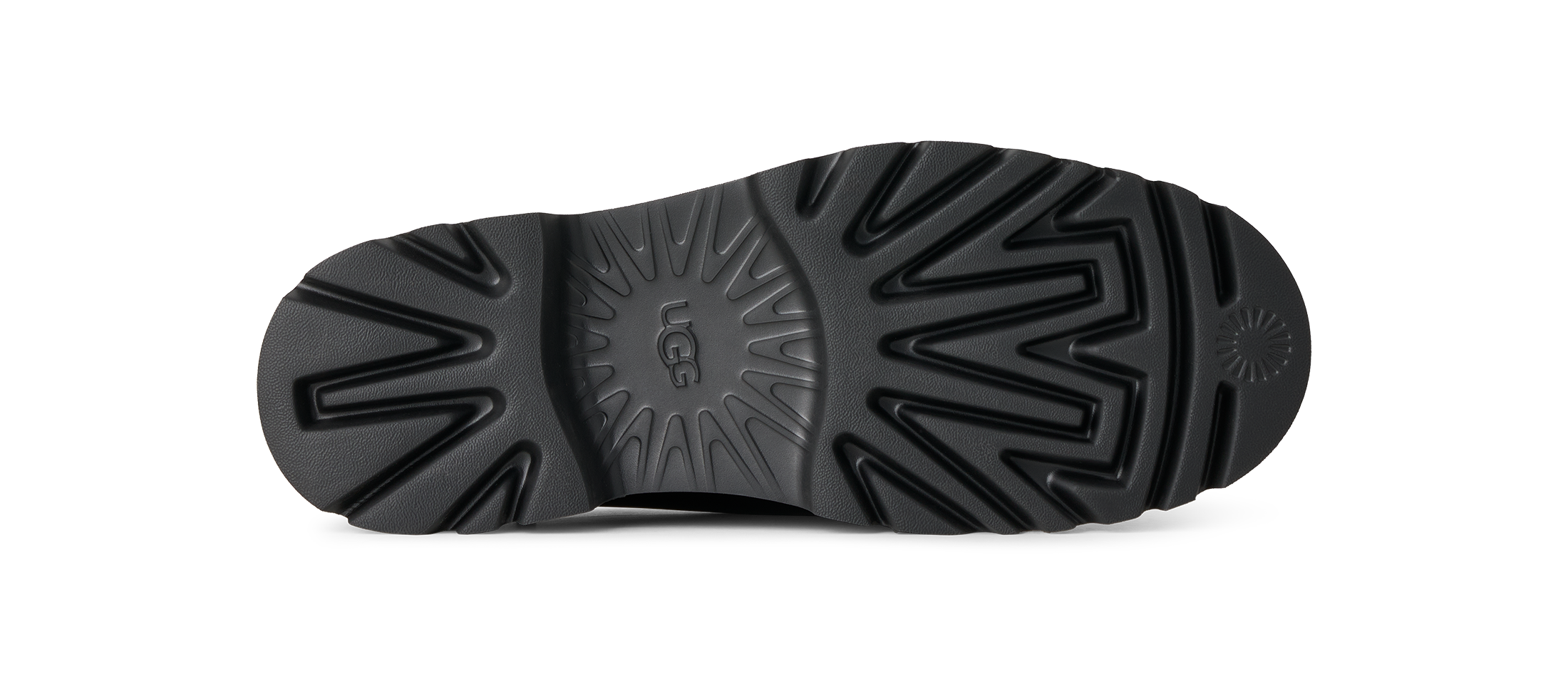 The black rubber outsole of a boot, showing deep tread patterns and the embossed UGG logo in the center, photographed on a solid white background.