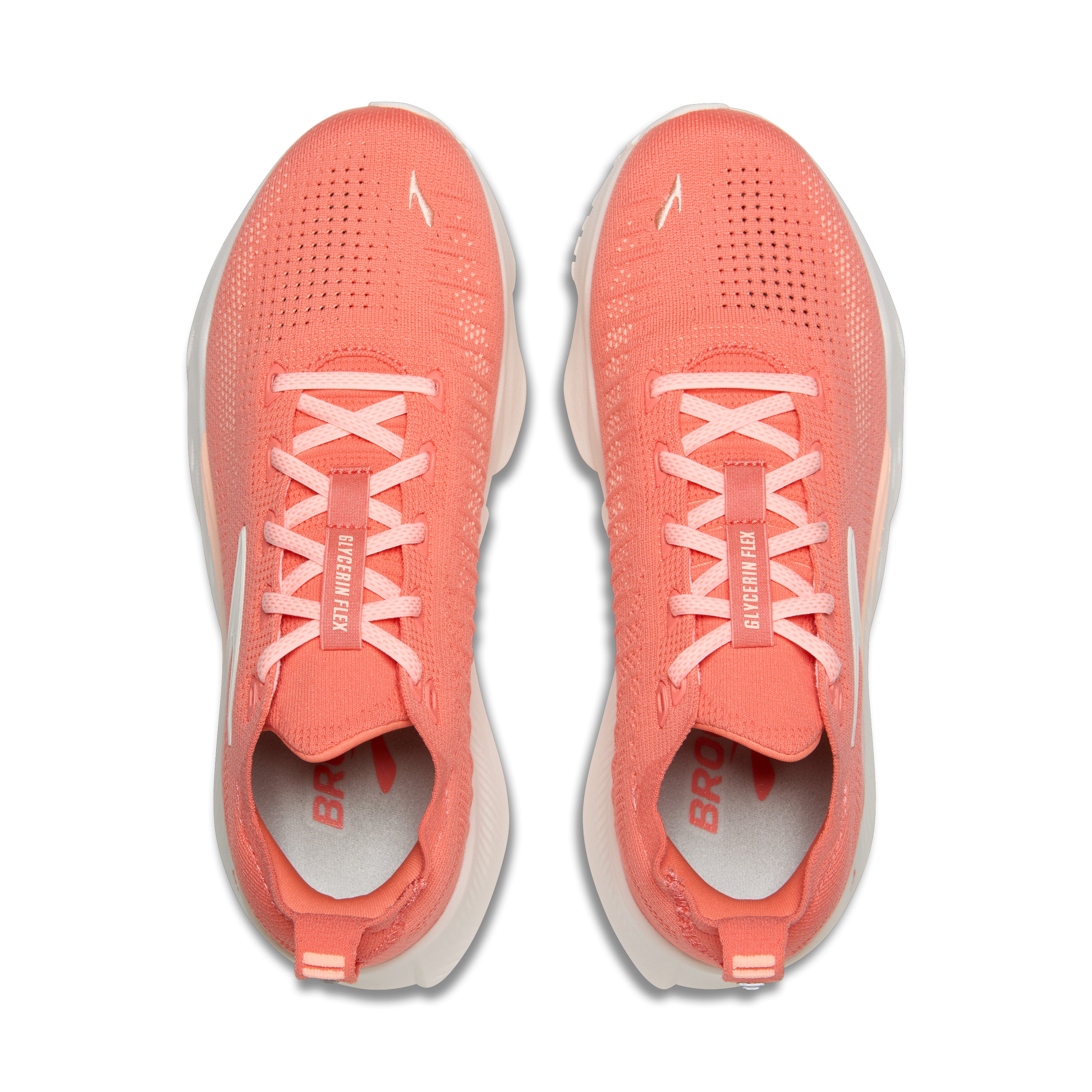 Pair of coral running shoes with white laces on a white background