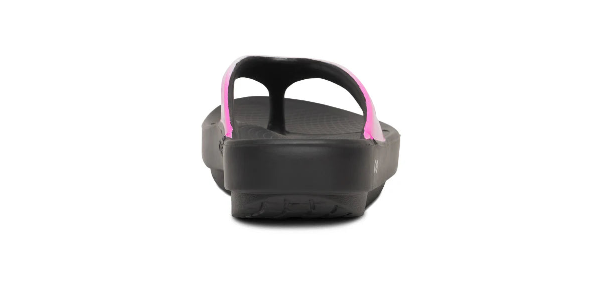 Black sandal with pink straps on a white background