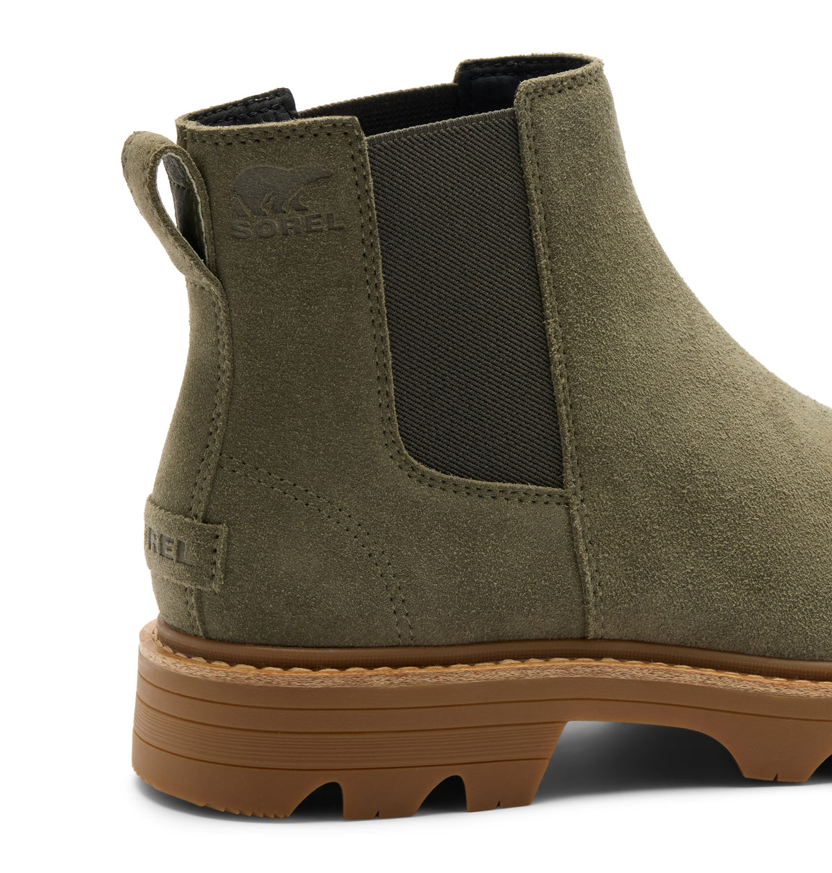 An olive green suede Chelsea-style ankle boot by sorel, shown from a rear three-quarter angle. The boot features a dark gray elastic side panel, a pull tab, and a chunky brown lug sole.