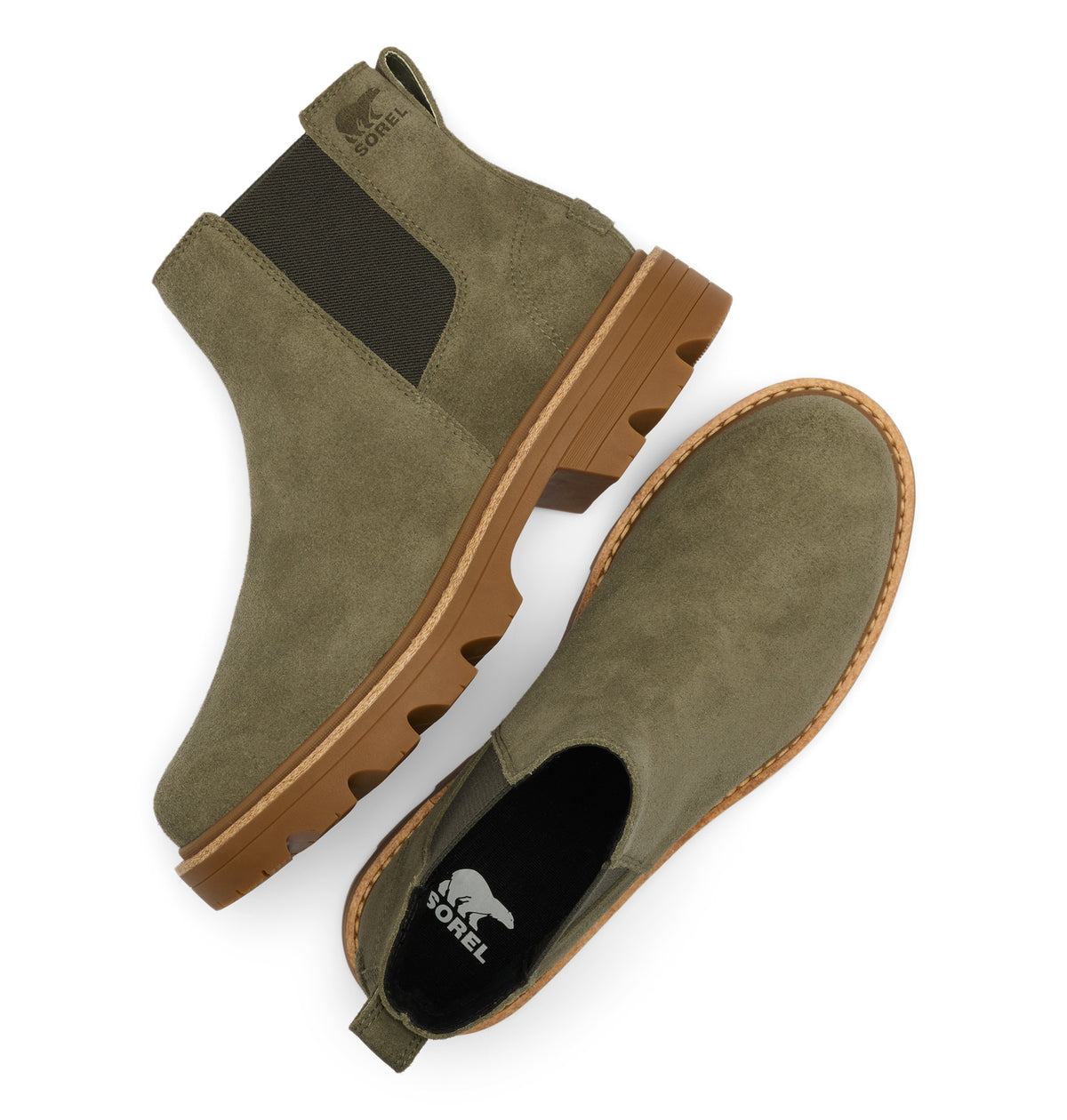 A pair of Sorel Chelsea boots in olive green suede, shown from a top-down angle on a white background. One boot is upright to show the dark elastic side panel and the brown lug sole, while the other lies on its side to show the black interior with the white Sorel bear logo.