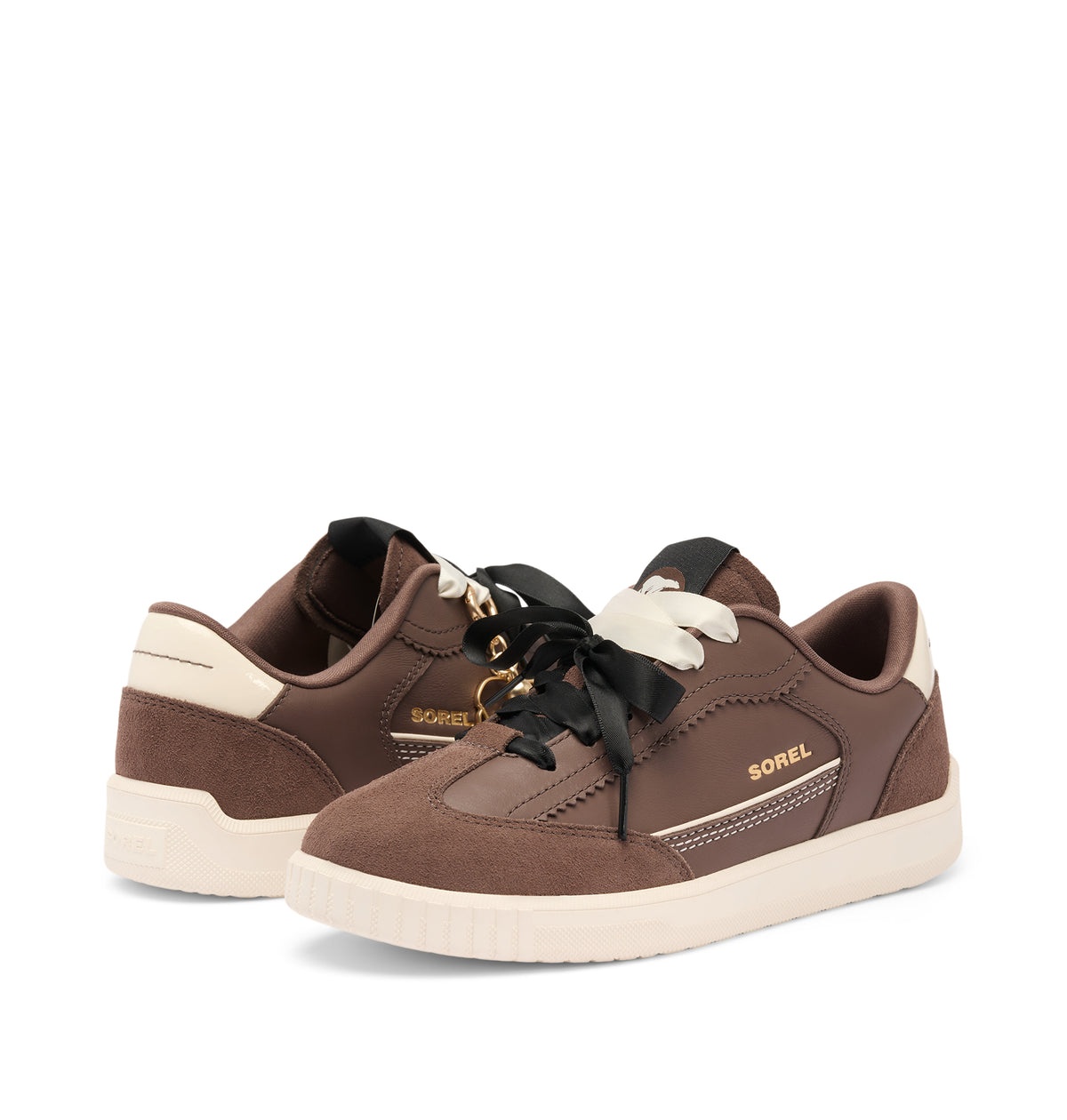 A pair of Sorel sneakers in brown suede and leather, featuring black laces with white tips, a cream-colored midsole, and gold Sorel branding.