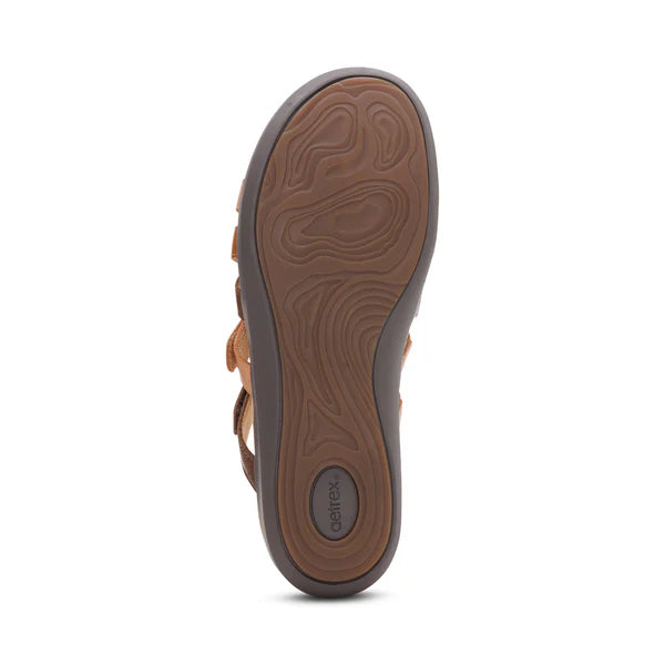 Brown sandal with a textured sole on a white background