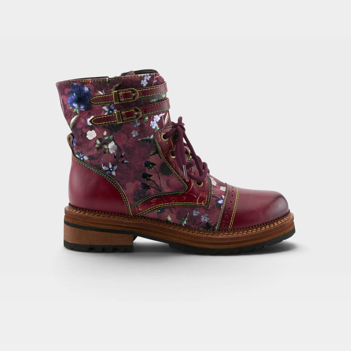 A single lace-up ankle boot in burgundy leather with a floral print on the side panels, featuring decorative straps with brass-tone buckles and a brown stacked sole, shown against a light gray background.