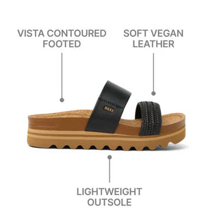Black sandal with brown sole on a white background, labeled 'Vista Contoured Footed', 'Soft Vegan Leather', and 'Lightweight Outsole'.