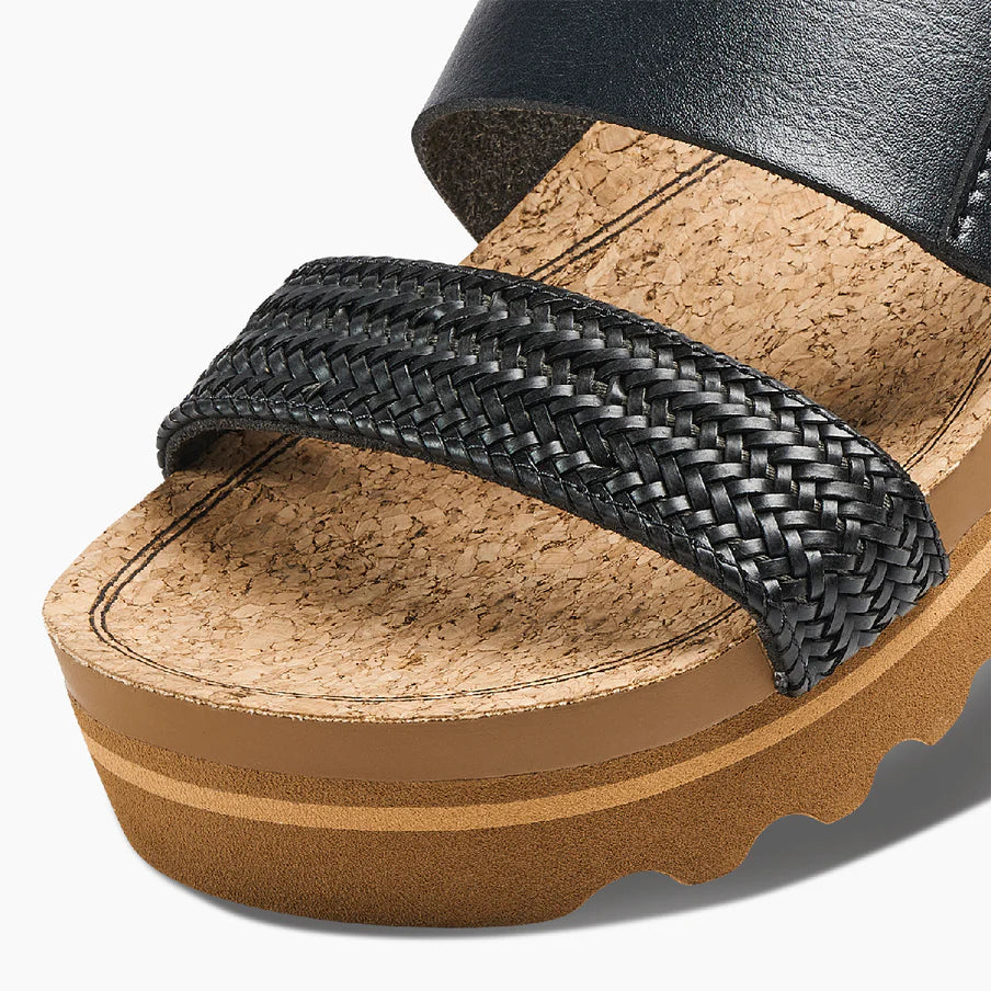 Black woven sandal with cork sole on a white background