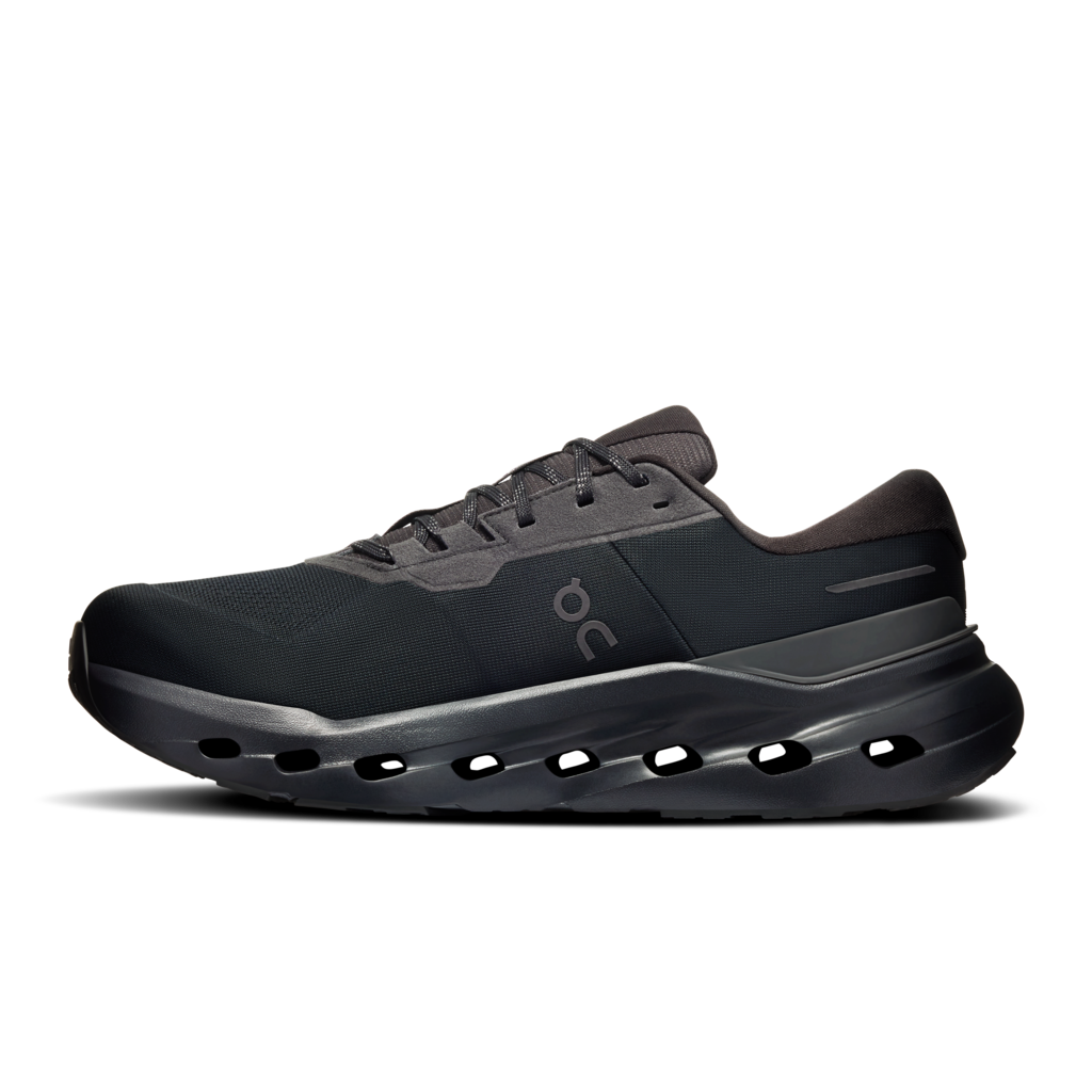 A dark gray and black athletic sneaker with a chunky sole and the On logo on the side, shown against a plain white background.