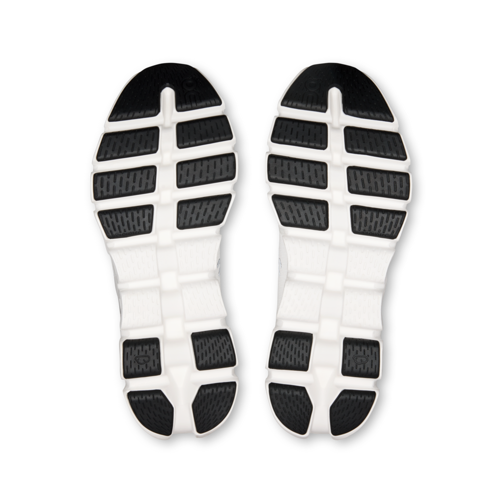 A pair of athletic shoe soles shown from above, featuring a white midsole with black textured outsole sections.