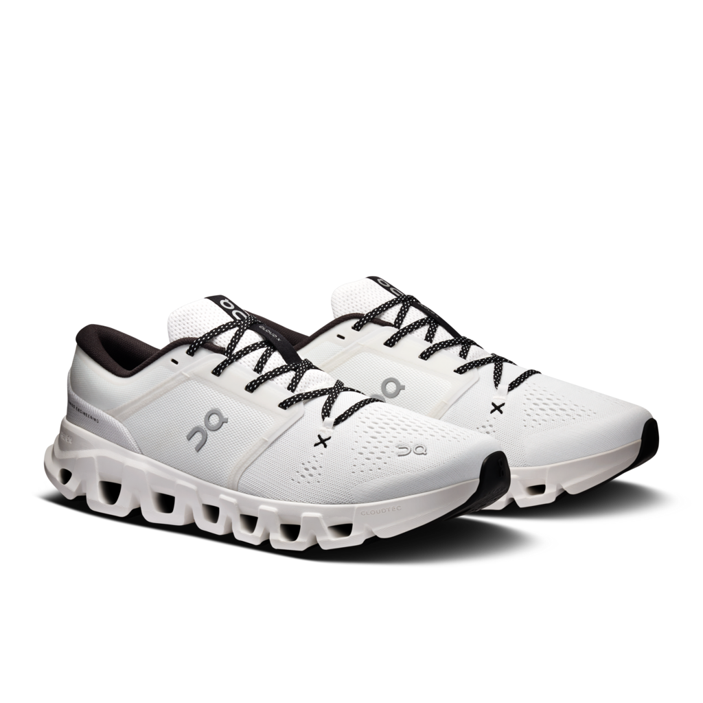 A pair of On running shoes in white with black laces, black accents, and a chunky white and black sole, shown on a clean white background.