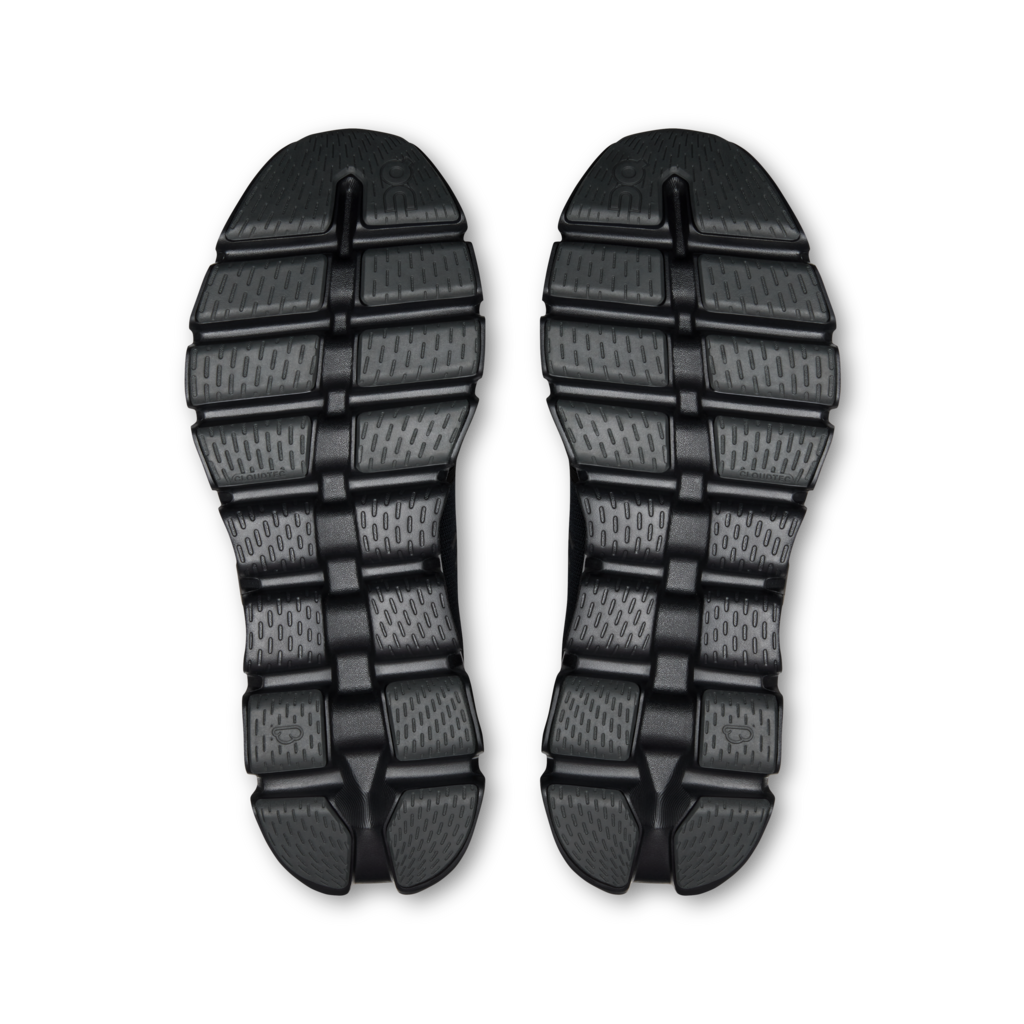 A pair of black rubber outsoles shown from above on a plain white background.