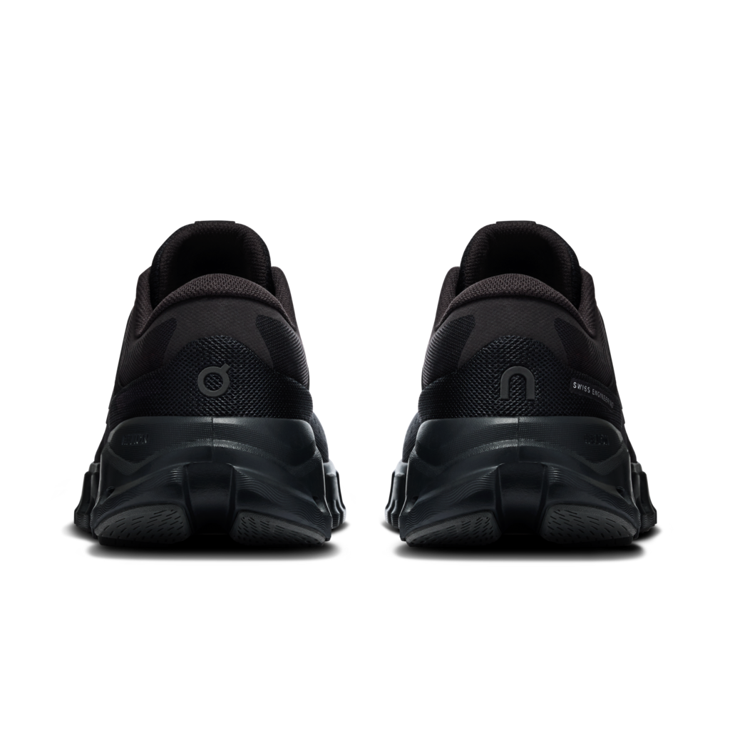 A pair of black athletic sneakers shown from the rear, featuring chunky sculpted soles and textured mesh uppers, set against a plain white background.