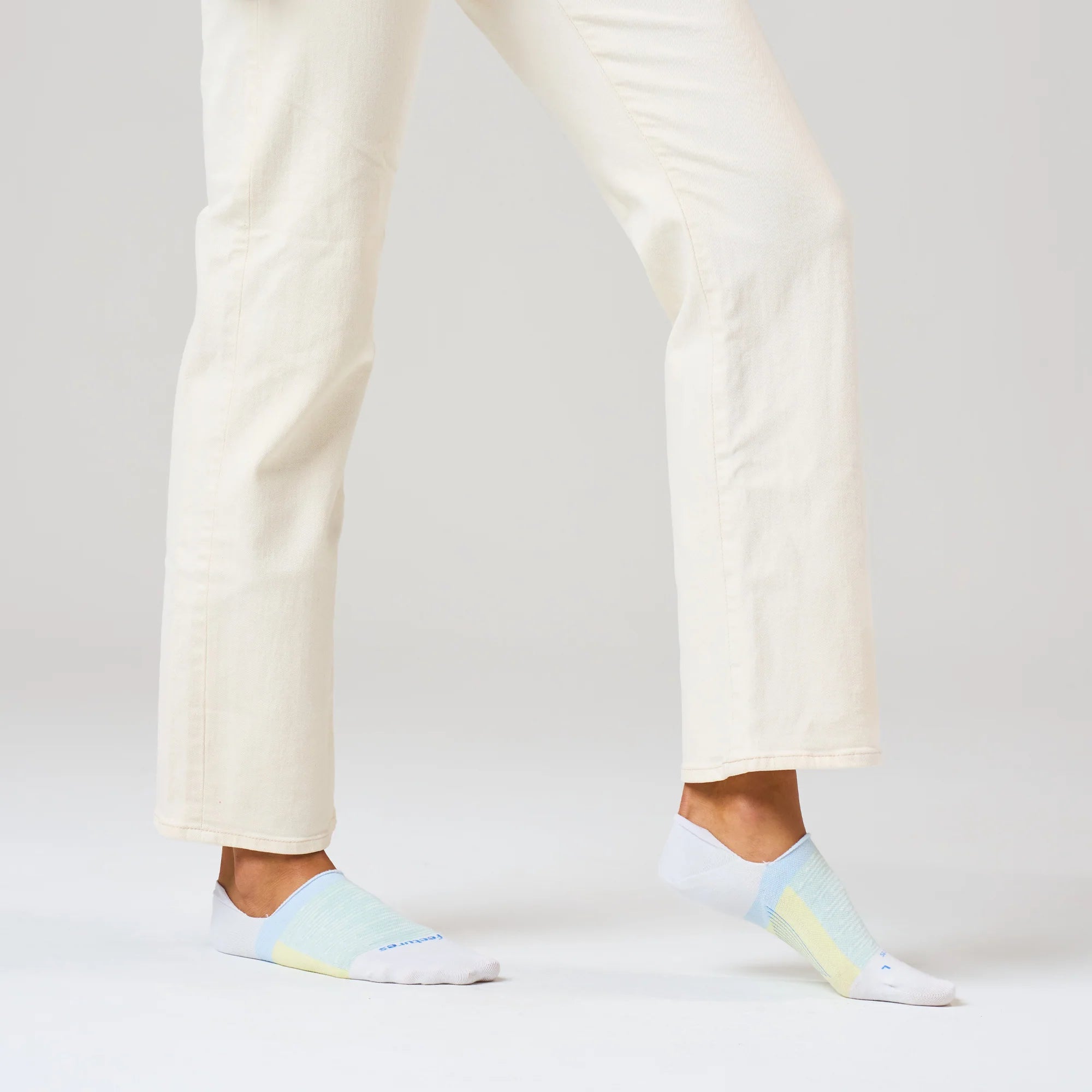 Person wearing light blue ankle socks with a subtle pattern on a plain background