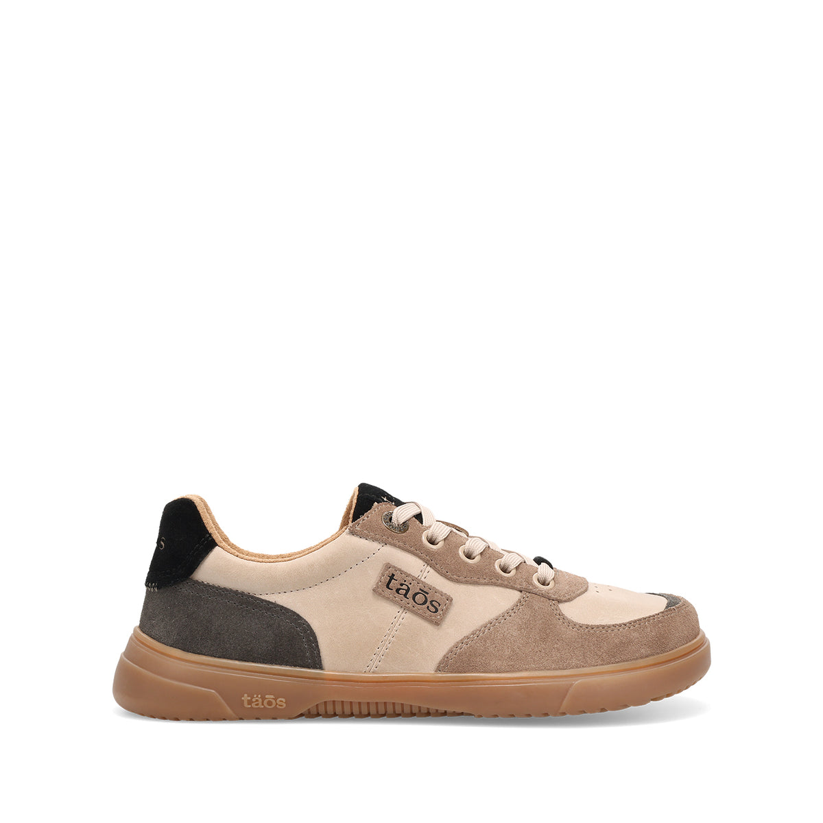 A low-top sneaker by taOS in beige, taupe, and brown suede, featuring a tan rubber sole and a black heel tab, shown from a side profile on a white background.