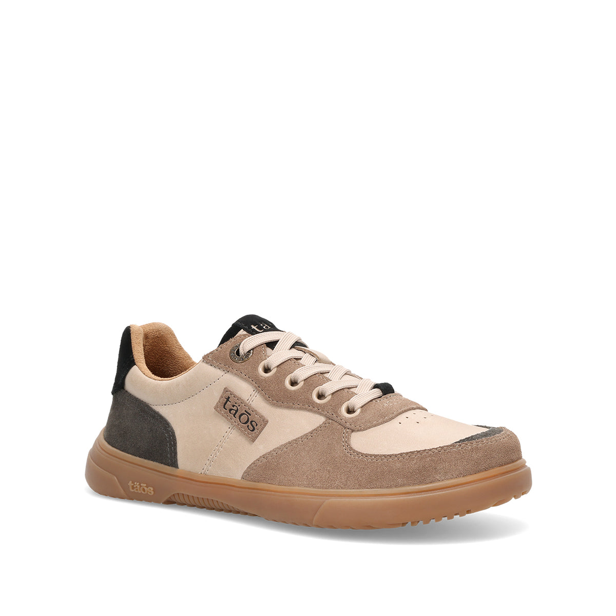 A Taos low-top sneaker in beige, taupe, and brown suede and mesh, featuring a gum sole and black accents on the tongue and heel.
