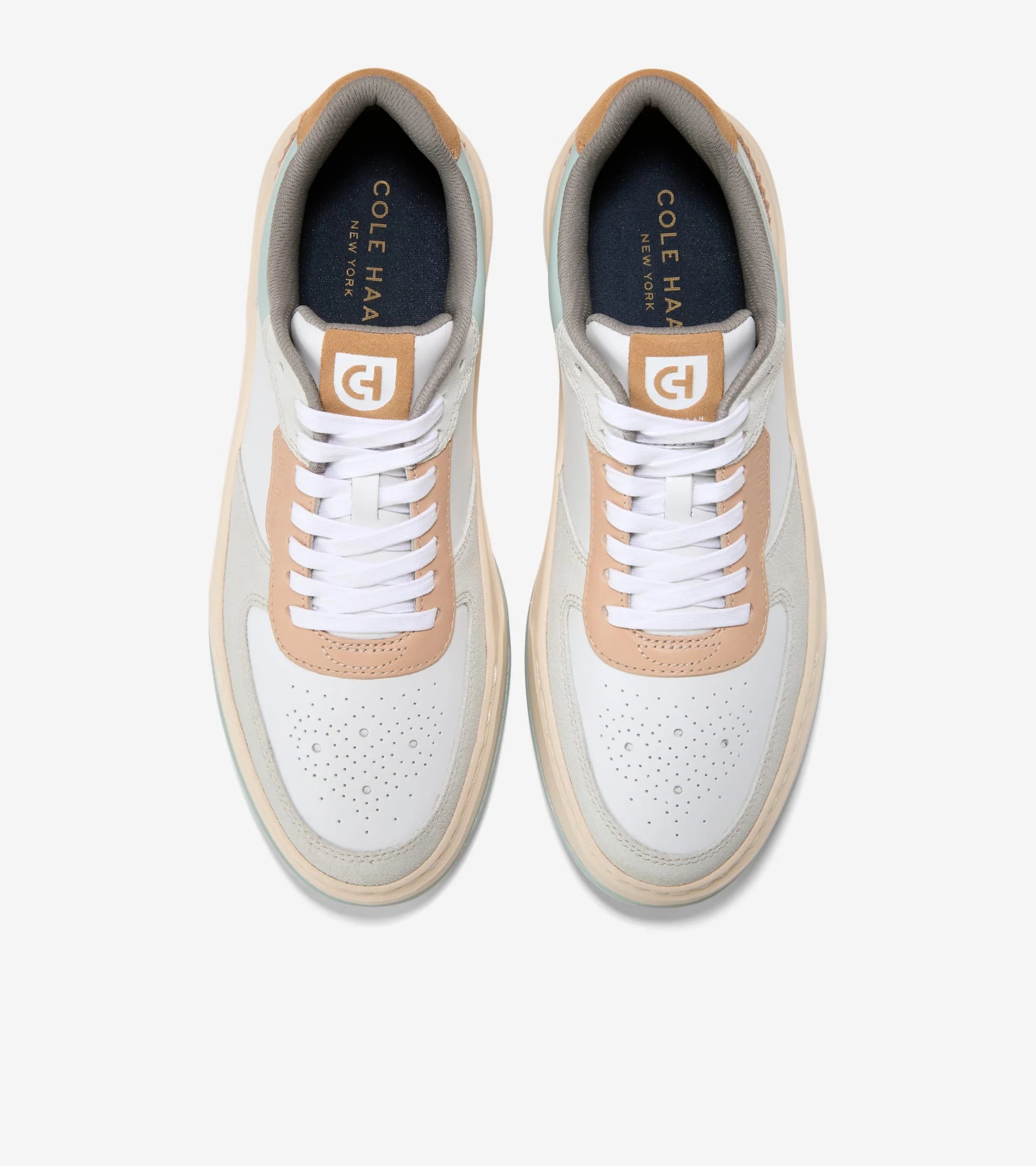 White sneakers with tan accents on a white background