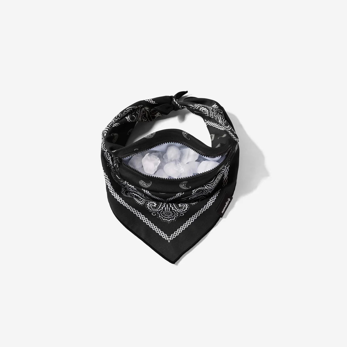 A black bandana-style neck gaiter with a white paisley pattern, shown with a clear plastic bag filled with ice inside, on a light gray background.