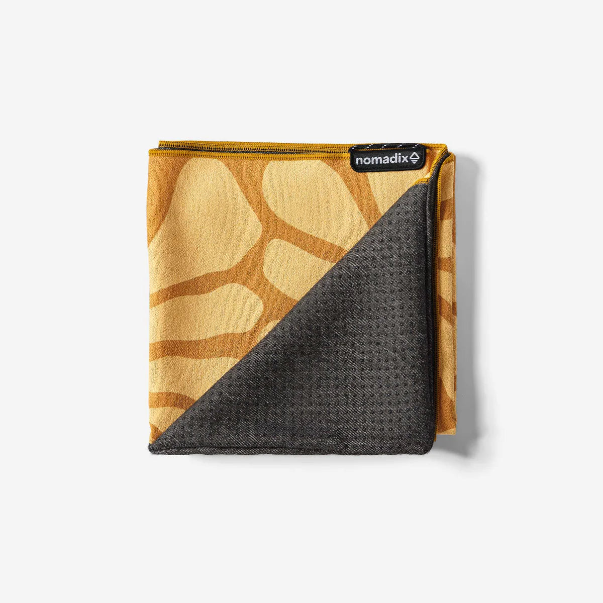 Folded towel with brown abstract pattern and gray textured side, branded 'nomadix'.