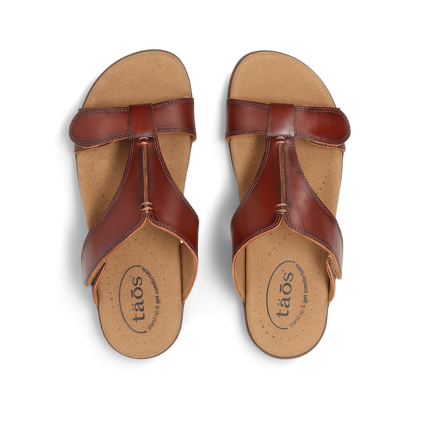 Pair of brown sandals with 'taos' branding on a white background