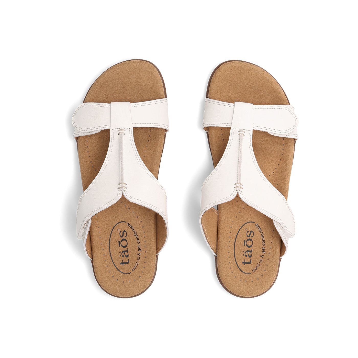 Pair of white sandals with tan soles on a white background