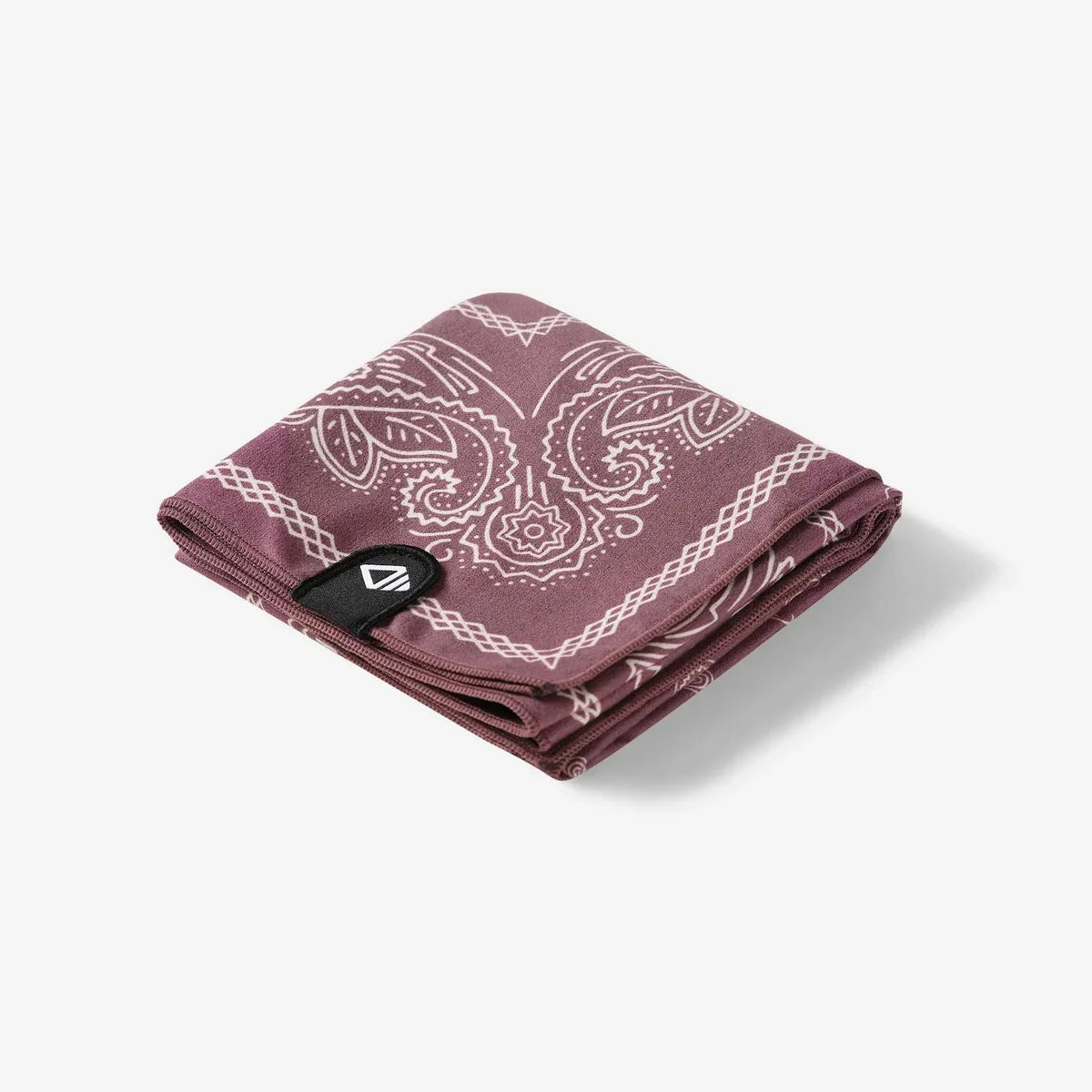 A folded dusty rose bandana with a white paisley pattern and a black brand tag, shown on a light gray background.