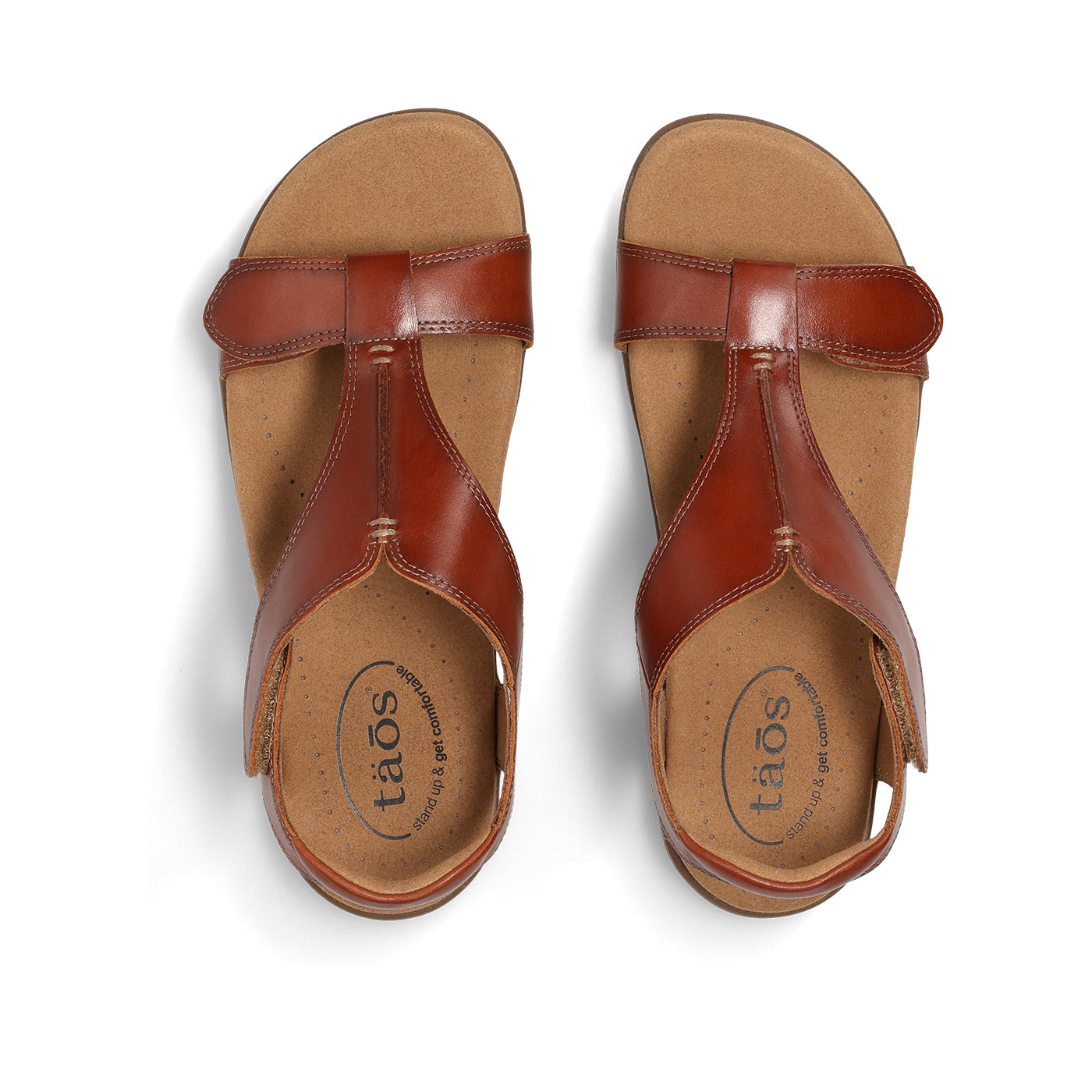 Pair of brown sandals with 'taos' branding on a white background