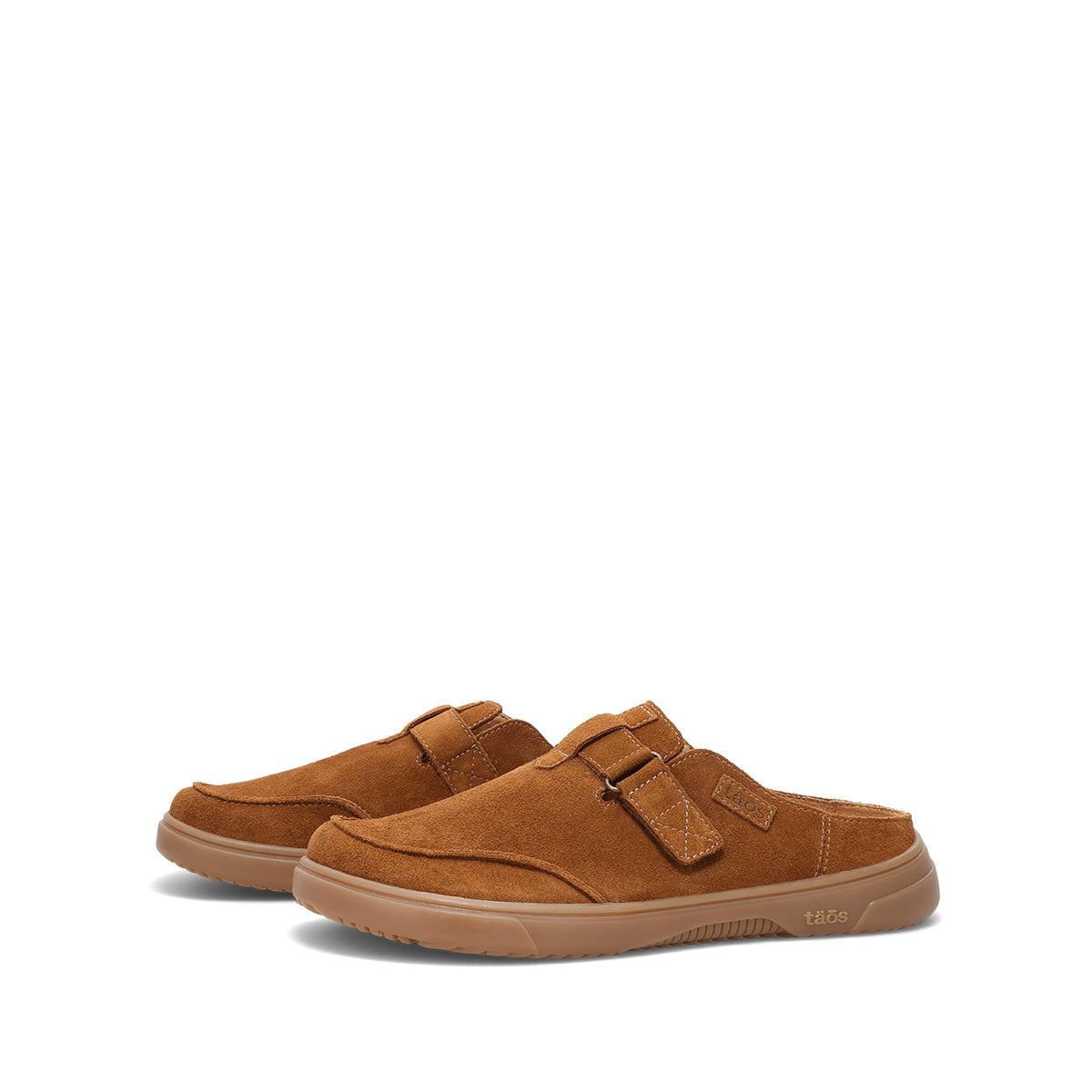 A pair of tan suede mule slip-on shoes with adjustable hook-and-loop straps and gum rubber soles, shown on a plain white background.