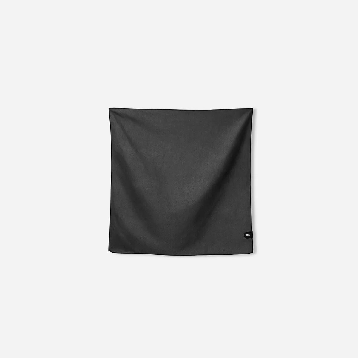 A black square scarf or bandana with a small black circular logo tag on the bottom right corner, displayed flat against a light gray background.