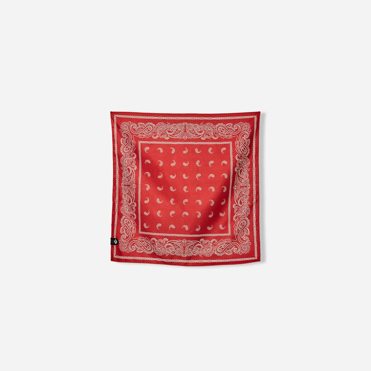 A square red bandana with a white paisley border and a central white paisley pattern, displayed flat against a light gray background.