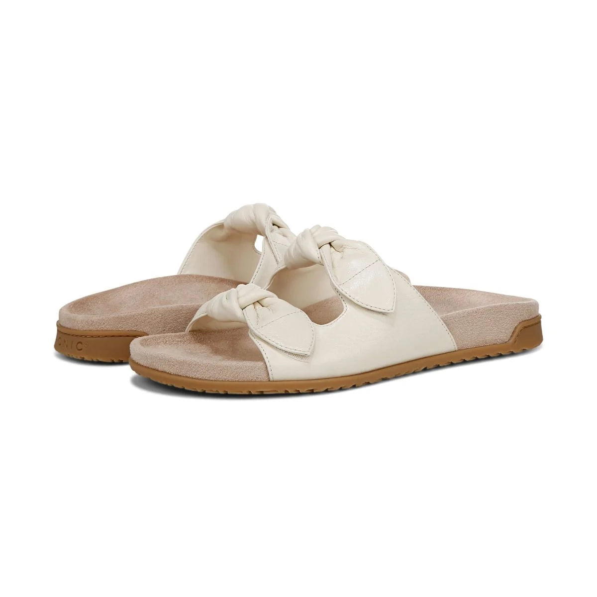 Pair of white sandals with brown soles on a white background