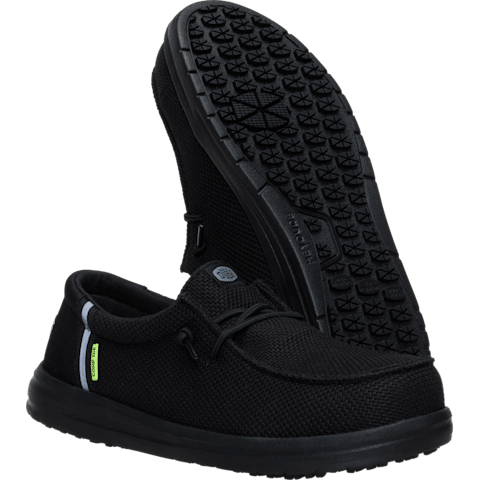 Black slip-on shoe with textured sole on a transparent background