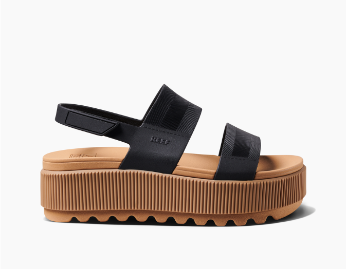 Black sandal with a brown platform sole on a white background