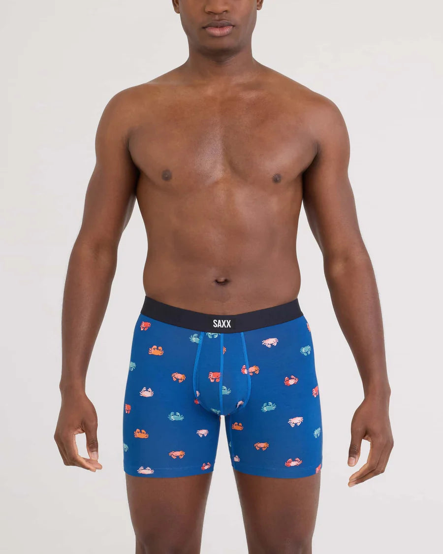 Man wearing blue boxer briefs with colorful car pattern and SAXX branding.