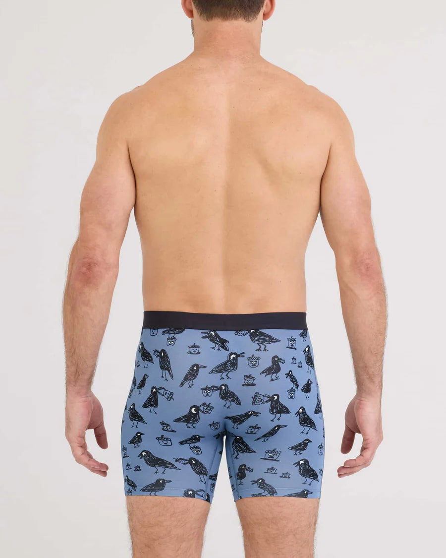 Man wearing blue boxer briefs with bird pattern on a white background