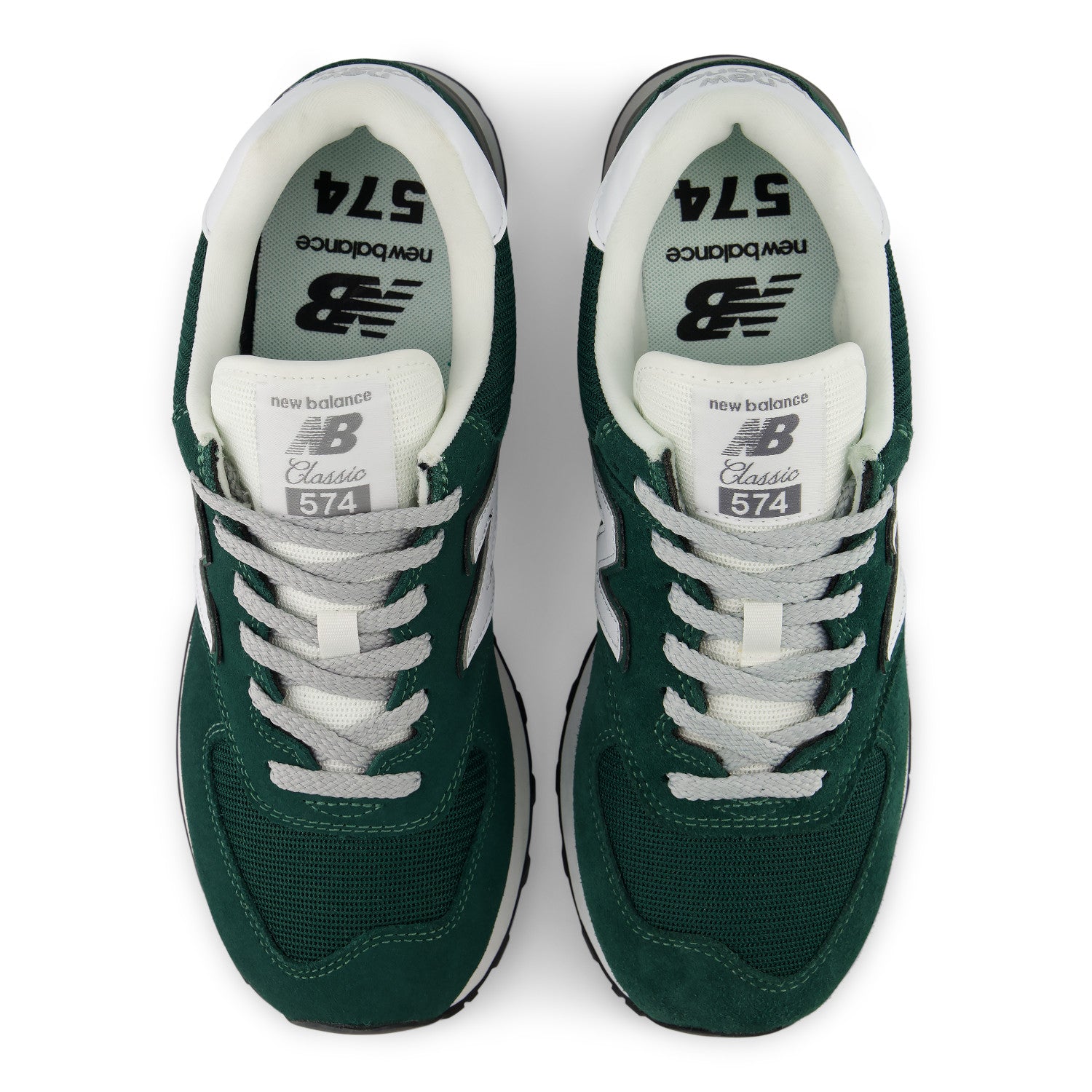 A pair of New Balance 574 Classic sneakers shown from a top-down view. The shoes feature a dark forest green mesh upper, white laces, a white collar, and white side stripes, with the New Balance logo and '574' printed on the tongue and footbed.