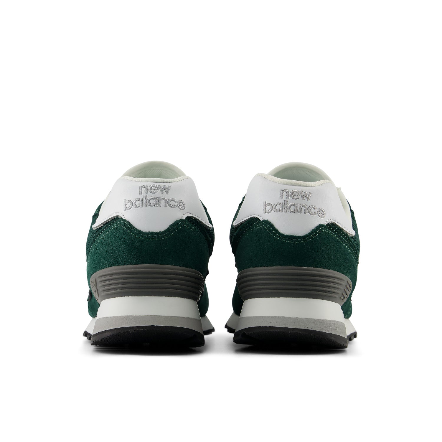 A pair of New Balance sneakers shown from the back, featuring a dark green suede upper, a white heel counter, and a white and gray midsole on a clean white background.