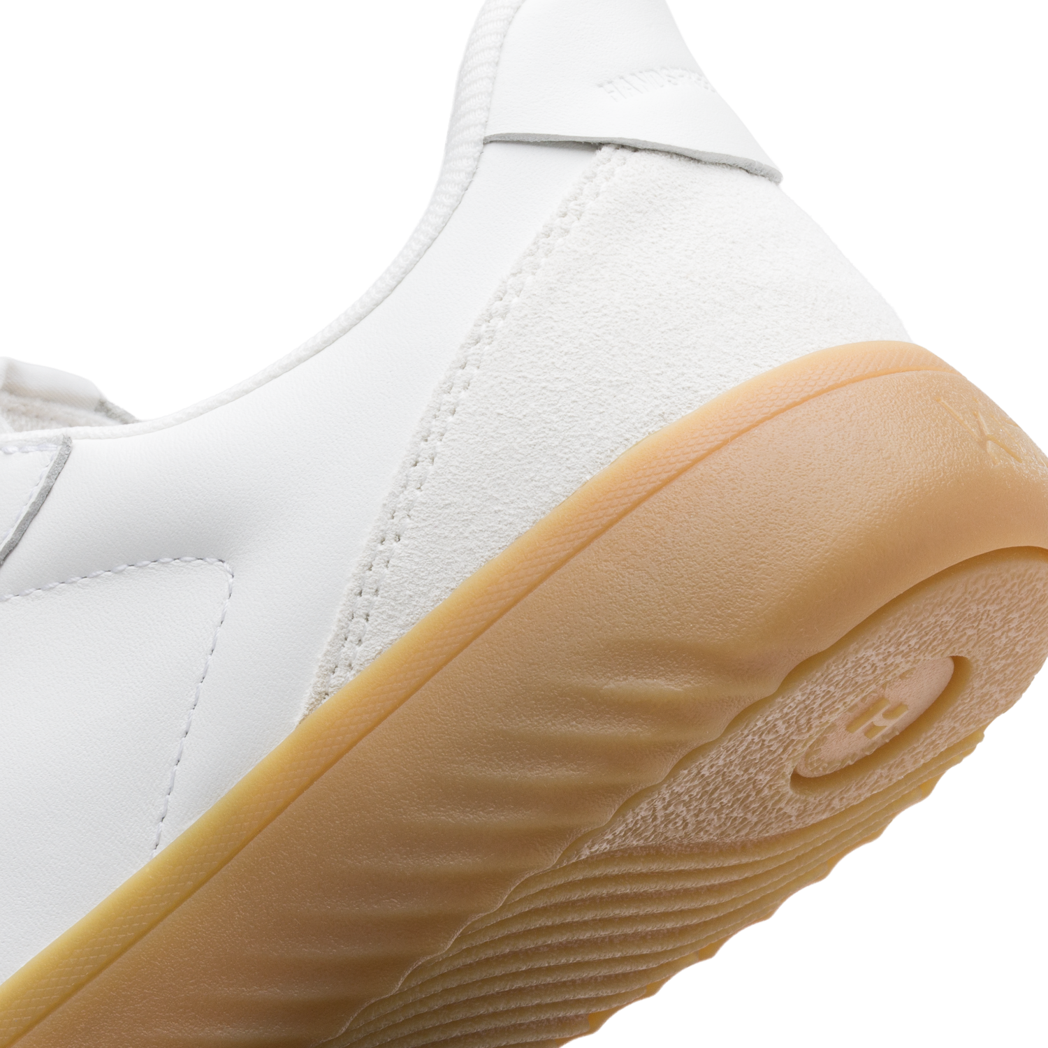 Close-up of a white sneaker with tan sole on a white background