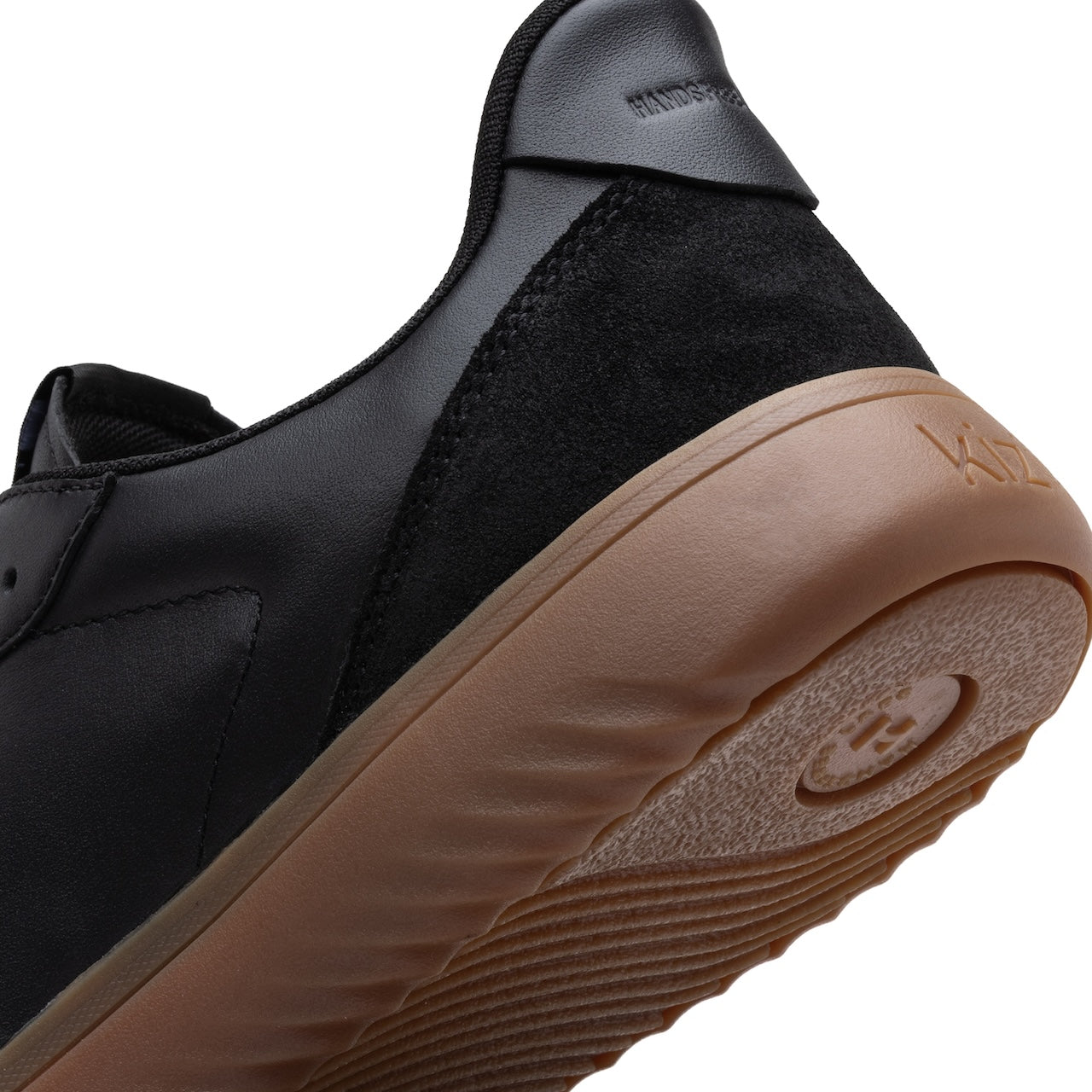 Black sneaker with brown sole on a white background