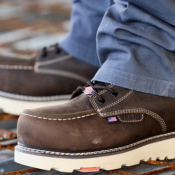 Close-up of brown work boots with a visible brand logo on a blurred background