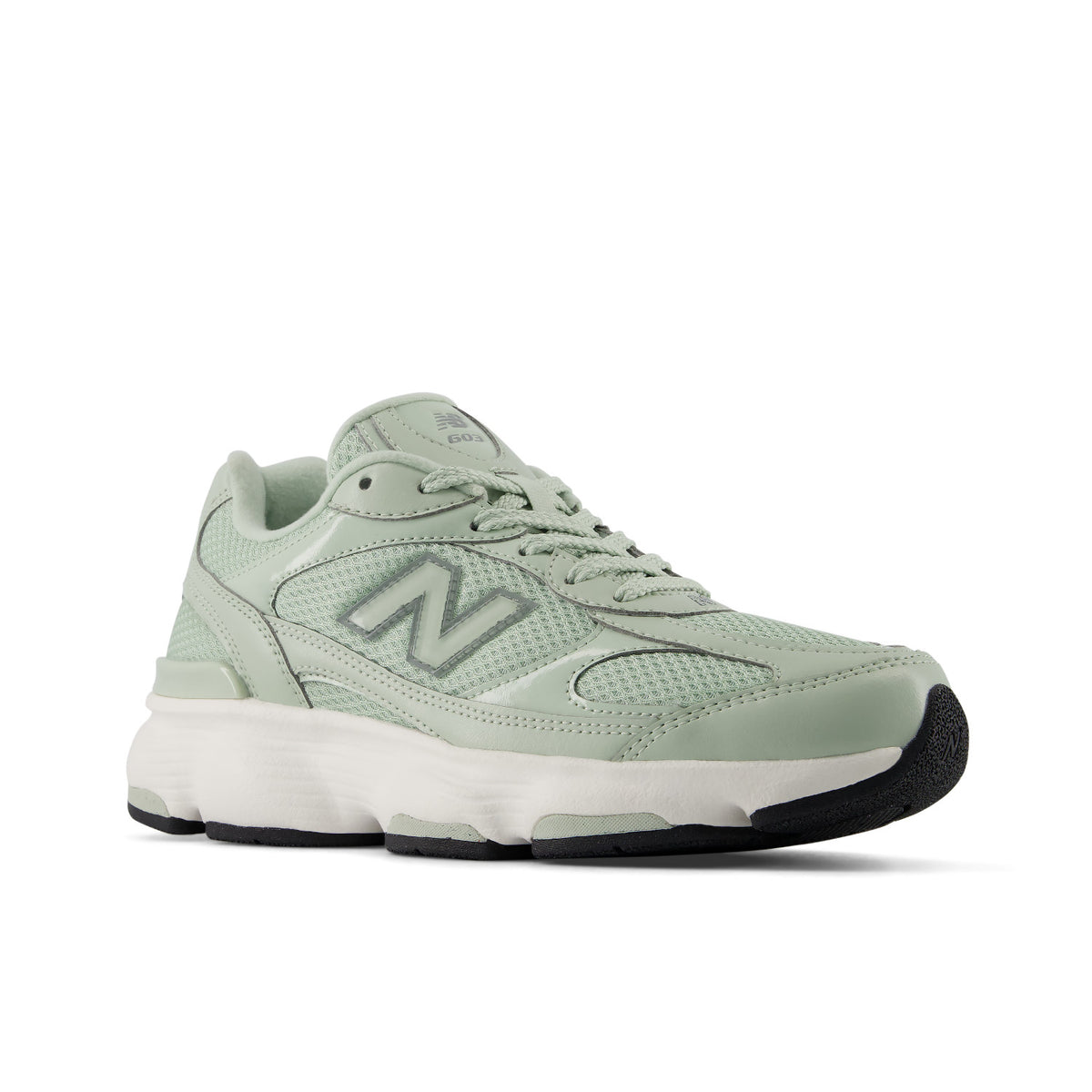 A New Balance sneaker in a light sage green colorway, featuring a mesh and synthetic upper, matching green laces, a chunky white midsole, and a black outsole.