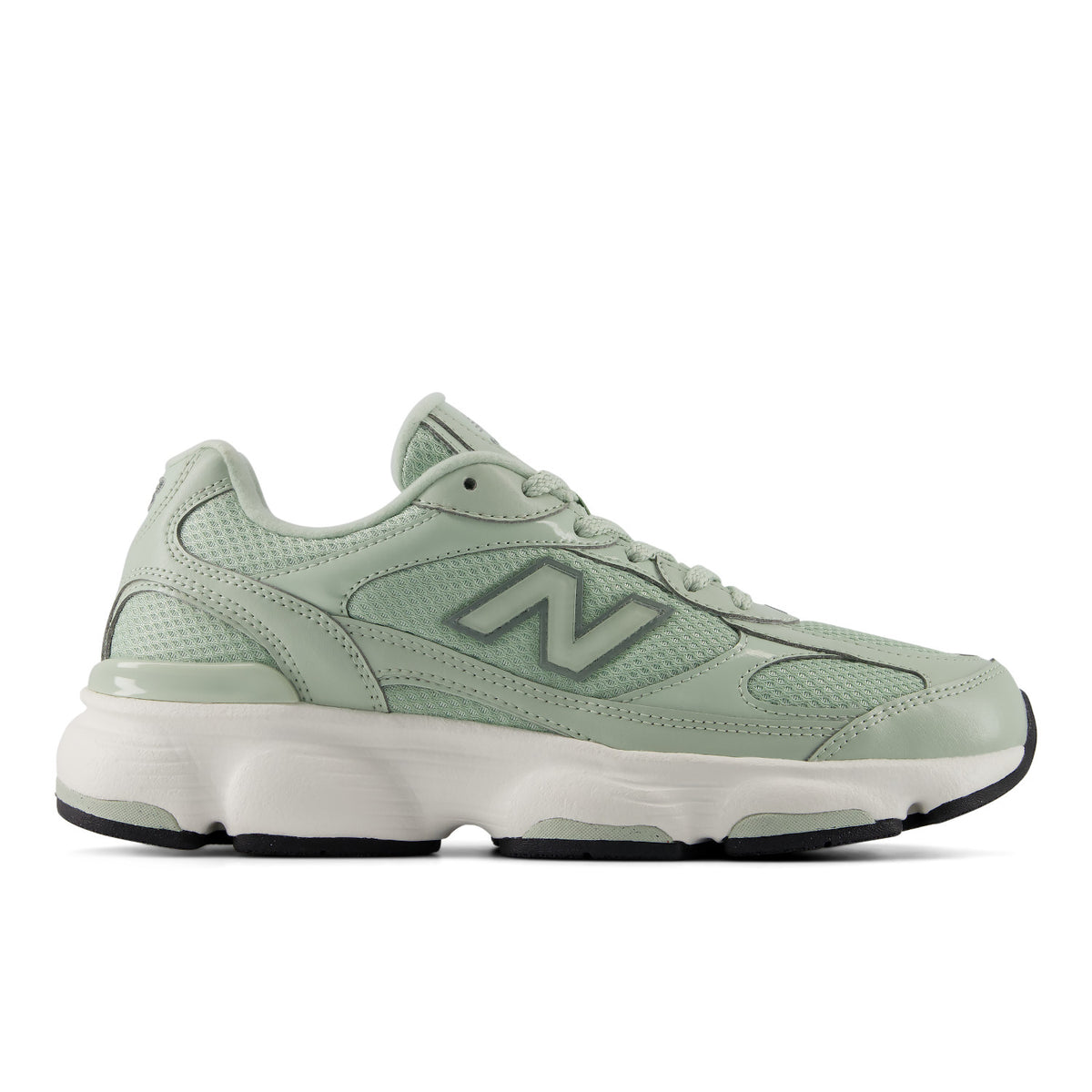 A New Balance sneaker in a light sage green colorway, featuring a mesh and synthetic upper, matching green laces, a thick white midsole, and a black outsole.