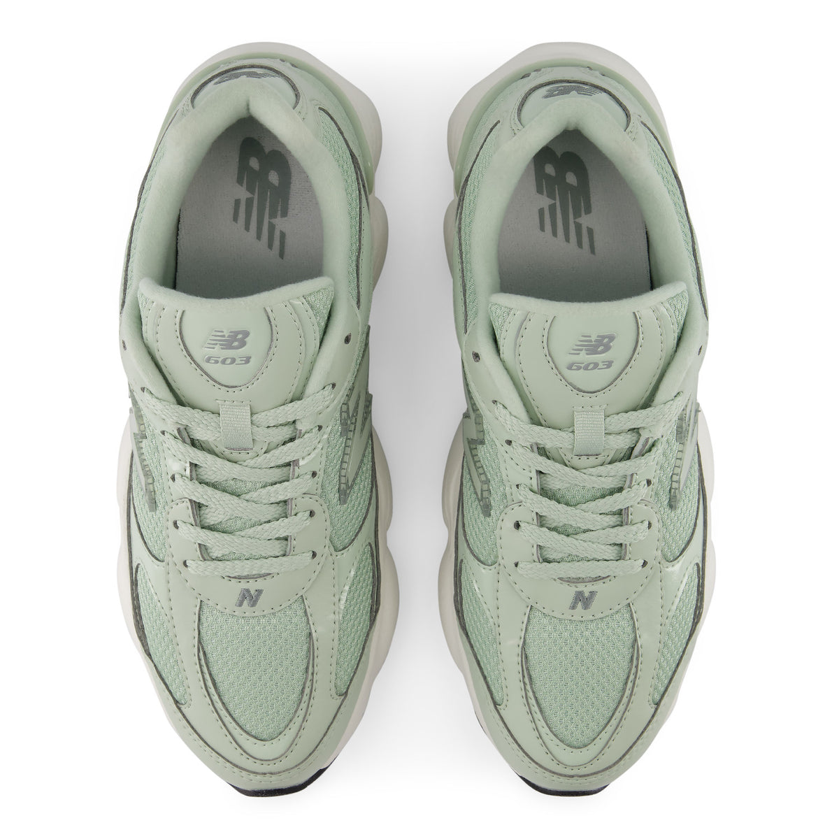 A pair of New Balance 603 sneakers in a light sage green colorway, shown from a top-down view on a white background.