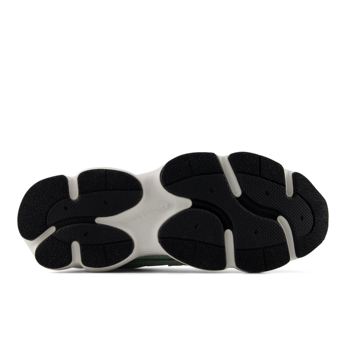 The outsole of a black boot with a white midsole section, photographed from a top-down perspective on a light gray background.