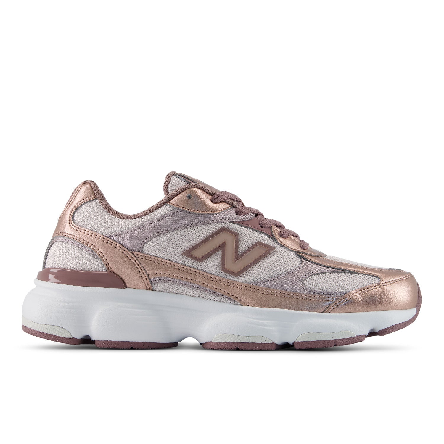 A New Balance sneaker in metallic rose gold and light purple mesh, featuring a chunky white midsole and a metallic rose gold 'N' logo on the side, shown against a plain white background.