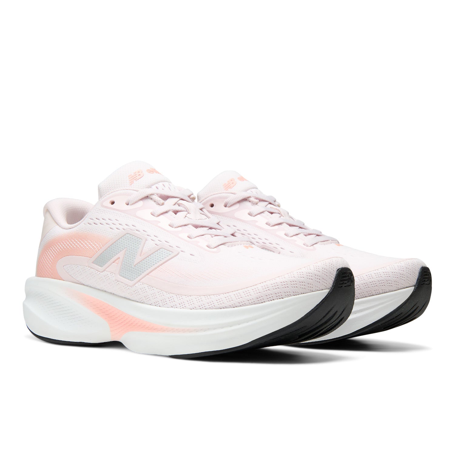 A pair of New Balance running shoes in light pink and white with coral accents, shown from a side profile view on a white background.